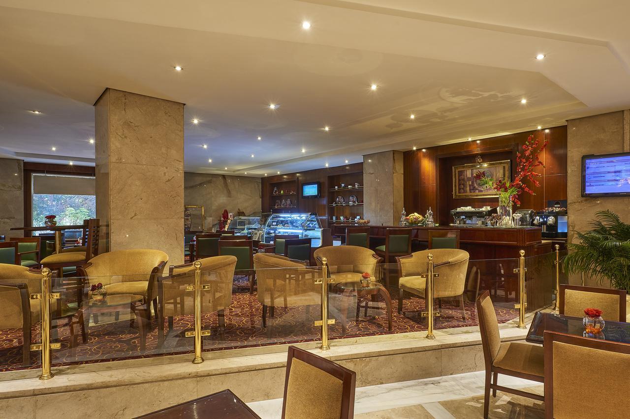 Safir Hotel Cairo Giza Exterior foto The photo shows the interior of a café or restaurant. It features a well-lit space with modern decor, including comfortable seating arranged around small tables. There are elegant, plush chairs and a section that appears to be a counter or bar area, 